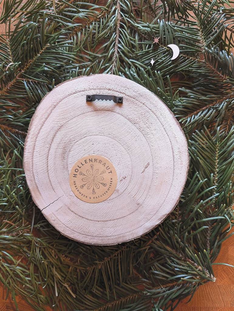 Die Rückseite der Baumscheibe mit Bildaufhängung und Hollenkraut-Logo.