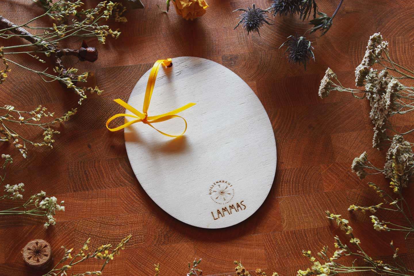 Die Rückseite des Holz-Ornaments: Darauf ist das Hollenkraut-Logo eingebrannt und darunter steht. LAMMAS