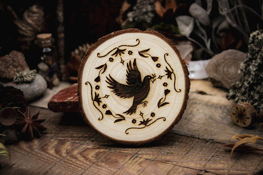 Holzgravur-Taube-Taubenhilfe, eine Taube umgeben vor mehreren Designelementen fliegt und trägt eine Pflanze im Schnabel, präsentiert in einer rustikalen Umgebung mit Kiefernzapfen,