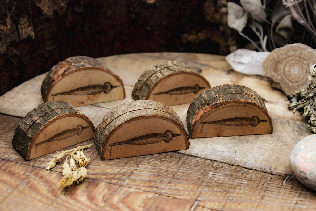 Verschiedene Kartenaufsteller mit witchy Motiven aus Holz mit rustikaler Rinde. Das eingebrannte Bild zeigt eine Spindel.