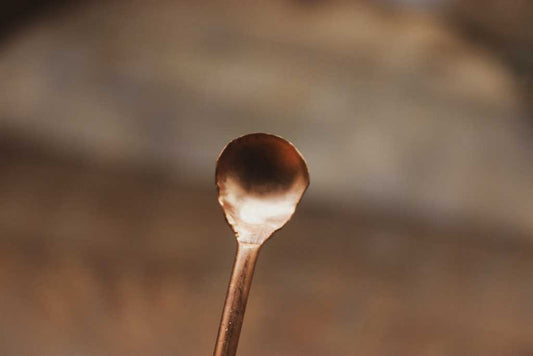 Ein schmaler langer Kupferlöffel.