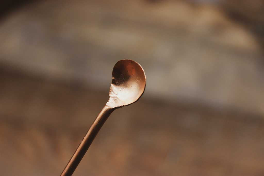 Ein schmaler langer Kupferlöffel.