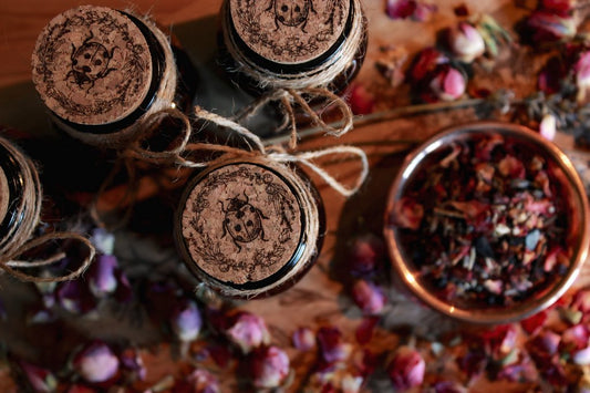 Nahaufnahme des Korkens des Räucherwerks. Auf den Korken ist das Motiv eines Marienkäfers eingebrannt. Drumherum ist ein Kranz aus verschiedenen Blumen. Im Hintergrund ist die Räuchermischung zu sehen.