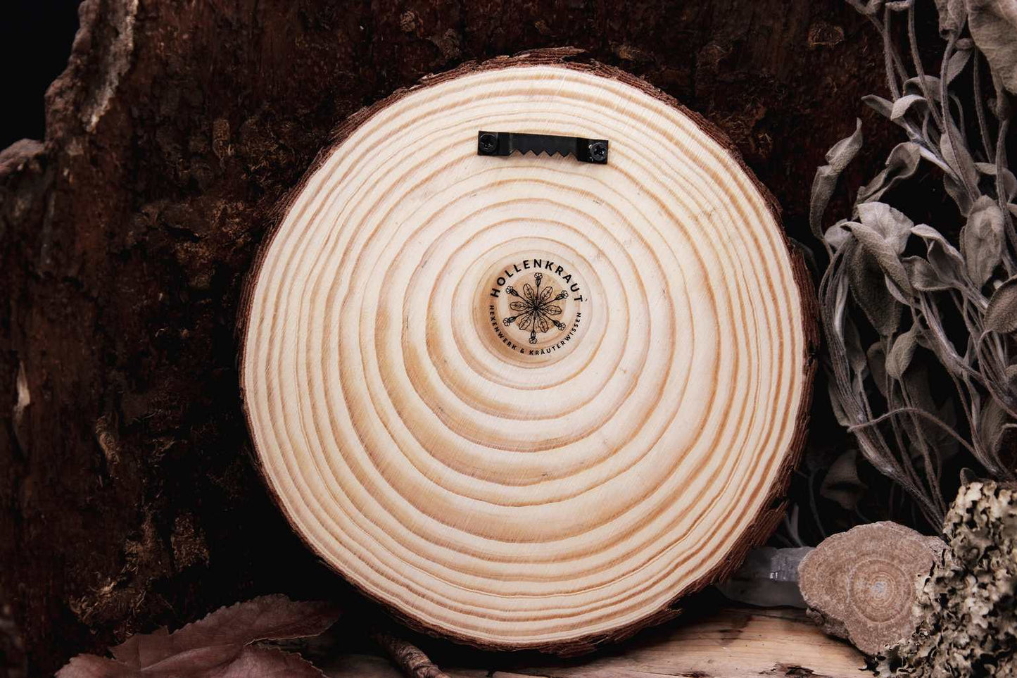 Die Rückseite der Baumscheibe mit angeschraubter Bildaufhängug und dem Hollenkraut-Logo.