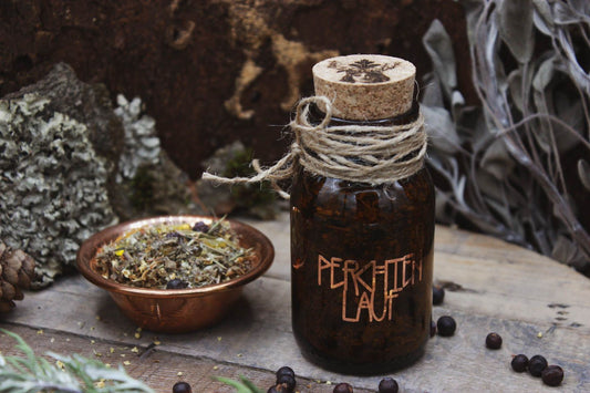 Räucherwerk in einem Braunglas mit Korken. Darauf steht in kupferner Schrift Perchtenlauf. Daneben steht eine Kupferschale gefüllt mit Räucherwerk. Drumherum liegen Wacholderbeeren verstreut.