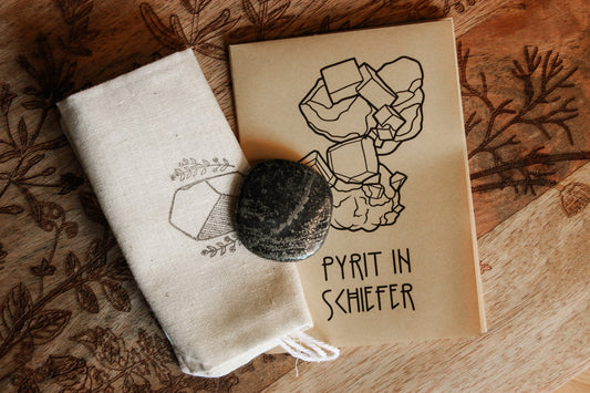 Pyrit in Schiefer Scheibenstein aus Deutschland -Pyrit in Schiefer Scheibenstein aus Deutschland - Pyrit in Schiefer Scheibenstein aus Deutschland - Bild von einem Pyrit auf einem natürlichen Hintergrund aus einem kleinen Booklet "Pyrit in Schiefer" und einer bedruckten kleinen Leinentasche