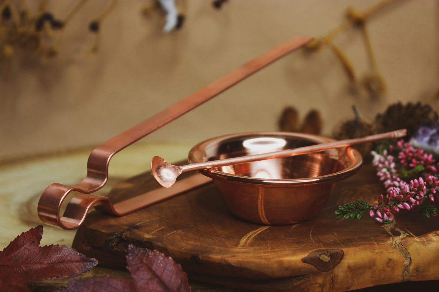 Räucherset: Zange, Schale, Löffel, Räucherkohle und Sand, Kupferzange und Schale, kunstvoll präsentiert auf einem rustikalen Holzbrett, umgeben von lebendigen, farbenfrohen Blumen und Blättern.