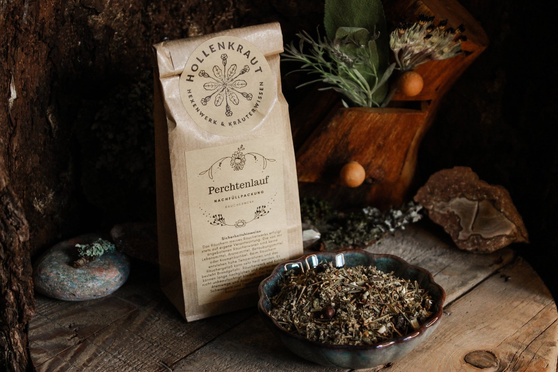 Räucherwerk Perchtenlauf - Räucherwerk - Das Bild zeigt eine “Perchtenlauf Nachfüllpackung Räucherwerk” neben einer Schale mit getrockneten Kräutern und Beeren auf einem hölzernen Hintergrund. Die Kräuter sind fein gemischt.