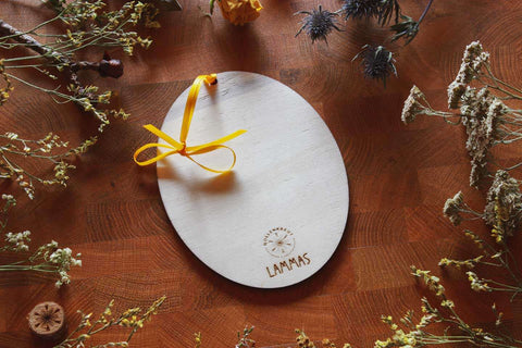 Die Rückseite des Holz-Ornaments: Darauf ist das Hollenkraut-Logo eingebrannt und darunter steht. LAMMAS