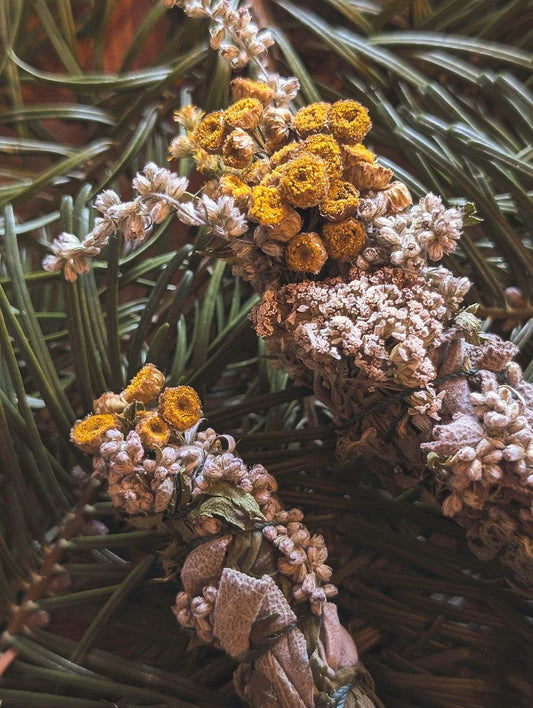 Nahaufnahme der beiden Räucherbündel. Besonders auffallend sind die gelben Blüten des Rainfarn.