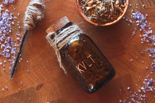 Räucherwerk im Braunglas im Apothekenstil mit Korken: Auf dem Glas steht „KVLT“ in kupferfarbenen Buchstaben, der Korken zeigt drei miteinander verwurzelte Bäume als kreisförmiges Symbol. Naturverbundenes, handgemachtes Räucherwerk für Rituale, Meditation und moderne Hexen.