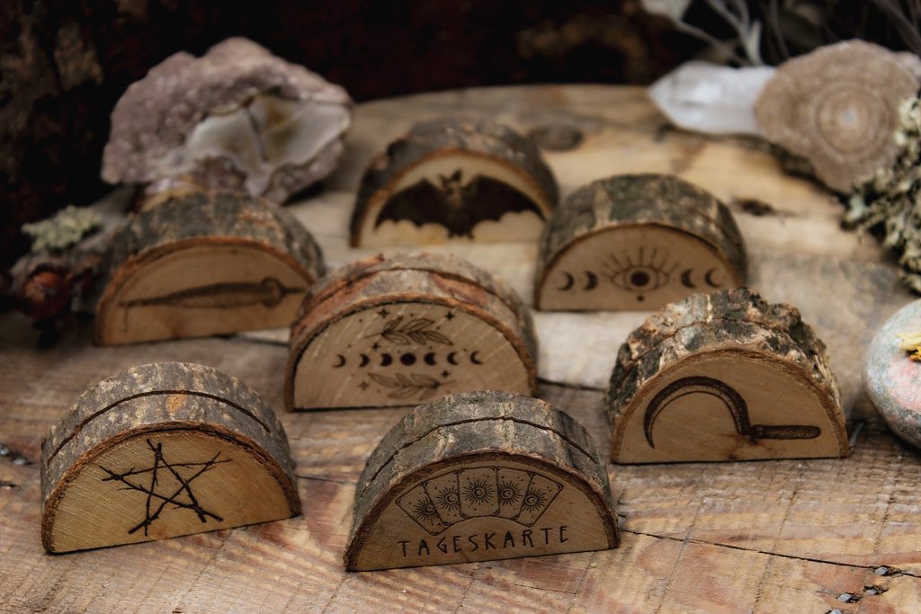 Verschiedene Kartenaufsteller mit witchy Motiven aus Holz mit rustikaler Rinde.