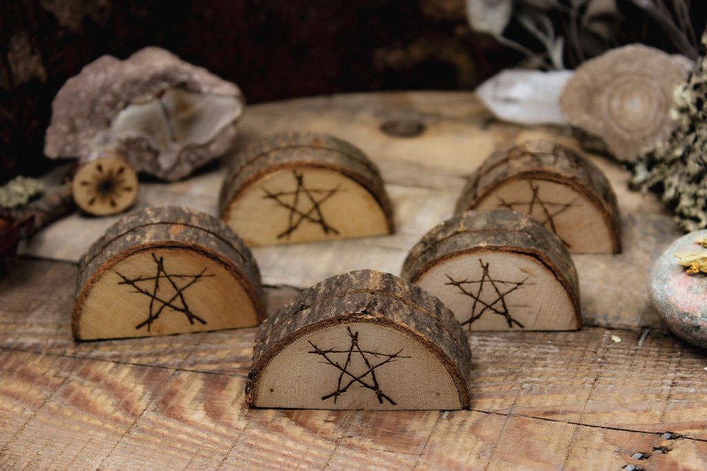 Verschiedene Kartenaufsteller mit witchy Motiven aus Holz mit rustikaler Rinde. Das eingebrannte Bild zeigt ein Pentagramm.