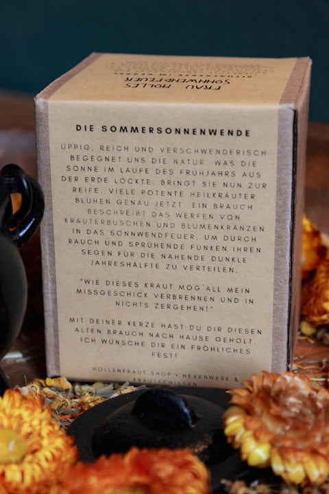 Umringt von gelben Blüten steht die Rückseite des Umkartons. Darauf ist zu lesen: Die Sommersonnenwende - Darunter in einem kleinen Text stehen Infos zu Litha.