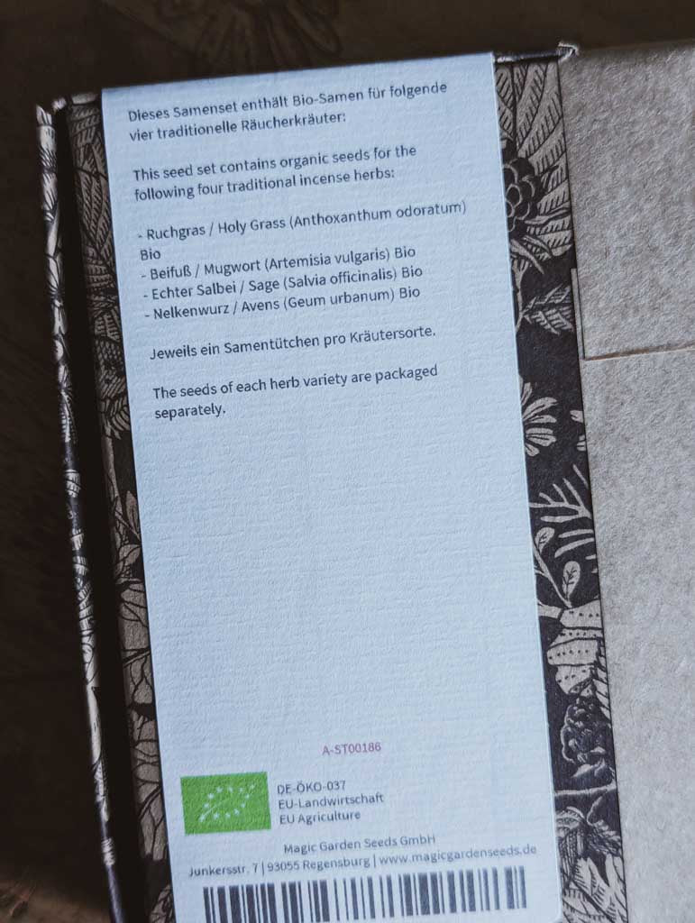 Saatgut Geschenkset in einer schön illustrierten Pappverpackung mit Kräutern und Insekten. Darauf steht: Magic Garden Seeds Samenset Aromatische Kräuter für das rituelle Räuchern - Rückseite  Nahaufnahme