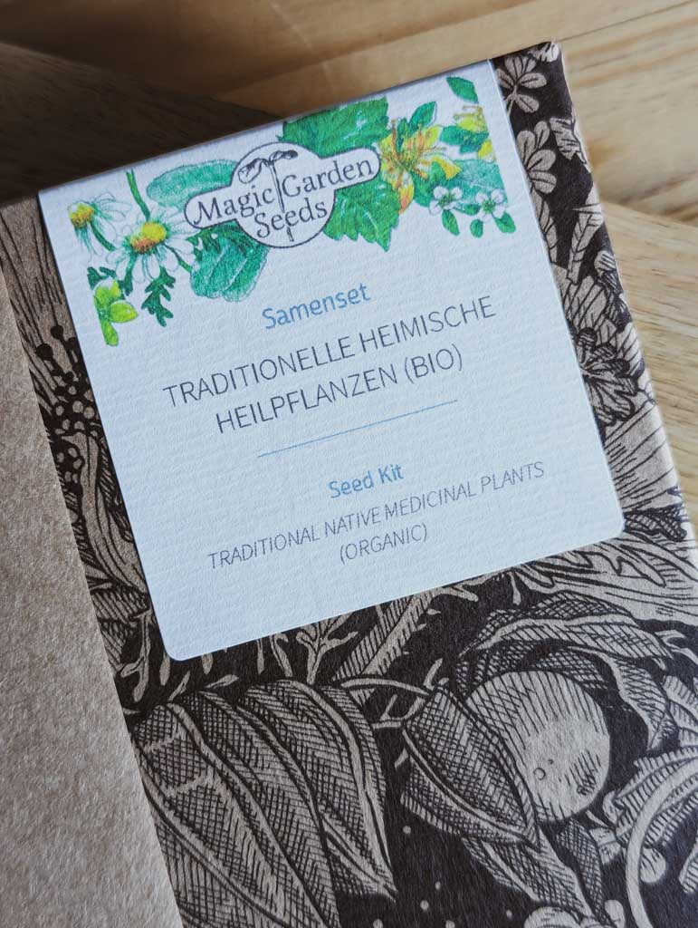 Saatgut Geschenkset in einer schön illustrierten Pappverpackung mit Kräutern und Insekten. Darauf steht: Magic Garden Seeds Samenset Traditionelle heimische Heilpflanzen - Nahaufnahme