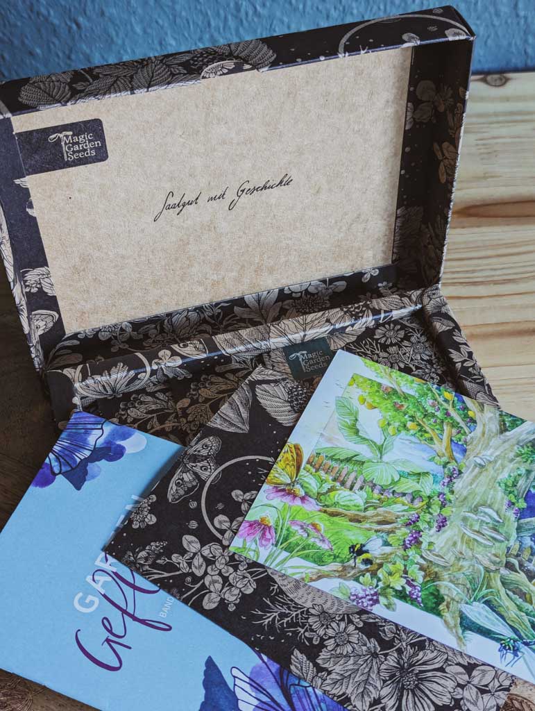 Saatgut Geschenkset in einer schön illustrierten Pappverpackung mit Kräutern und Insekten. Informationsmaterial und eine Postkarte sind zu sehen.
