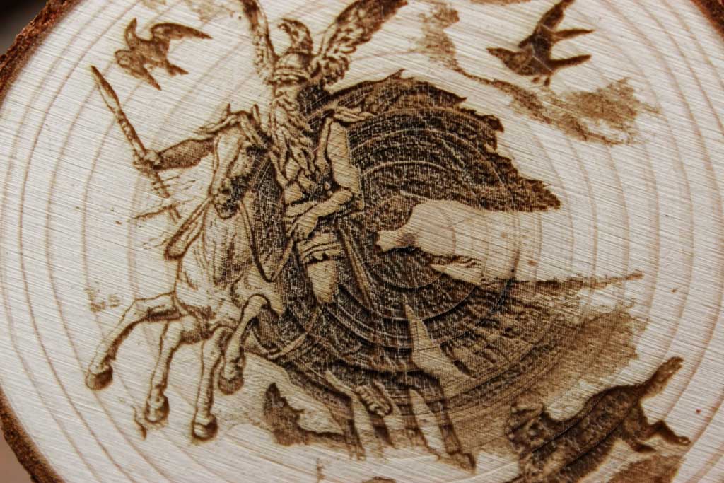 Baumscheibe mit dem eingravierten Motiv von Odin wie er auf seinem Pferd Sleipnir reitet. Nahaufnahme.