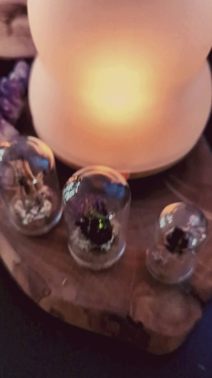 Ein Video der Kräuterlampe im Einsatz. Die Kamera macht einen Schwenk oben in den Glaseinsatz hinein. Dort steht eine leere Teelicht-Hülse aus Alu drin. Ein dunkles flüssiges Harz wird darin verdampft. Darunter steht ein Text: "Kleiner Tipp: Reine Harze kannst du in der Kräuterlampe räuchern, ohne den Glaseinsatz zu verschmutzen, indem du eine leere Teelichthülse aus Alu nutzt."