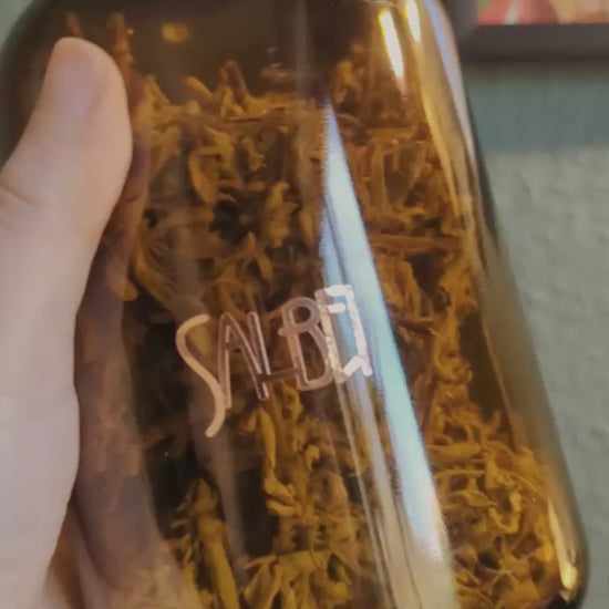 Anleitung bei der man sieht wie man Vinylsticker auf eine Flasche voller Kräuter anbringt