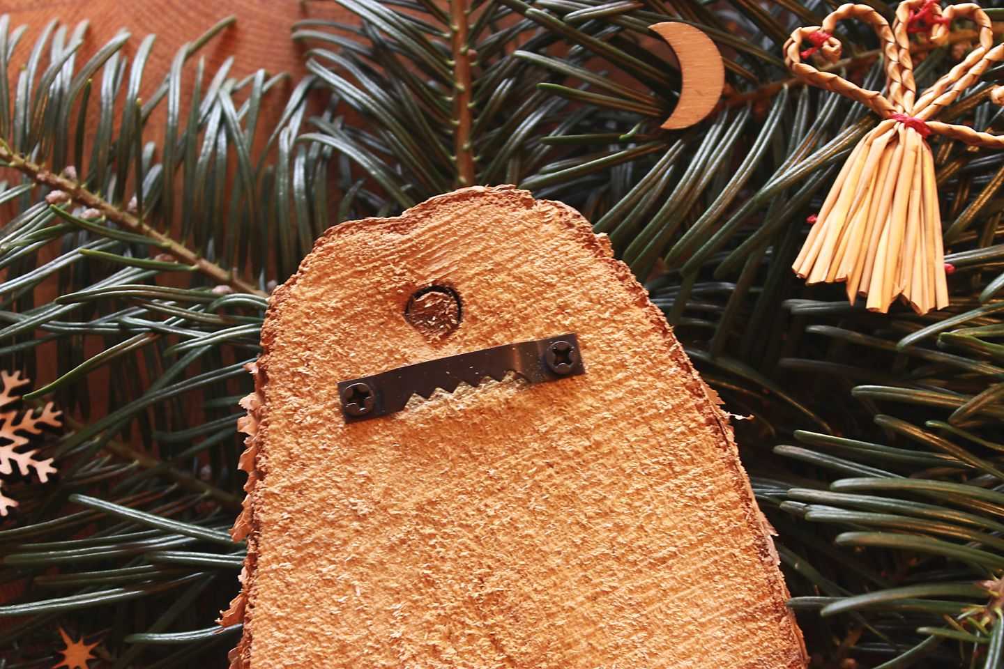 Rückseite des Holz-Bildes. Die Holzscheibe zeigt eine Aufhängung, die verschraubt wurde.